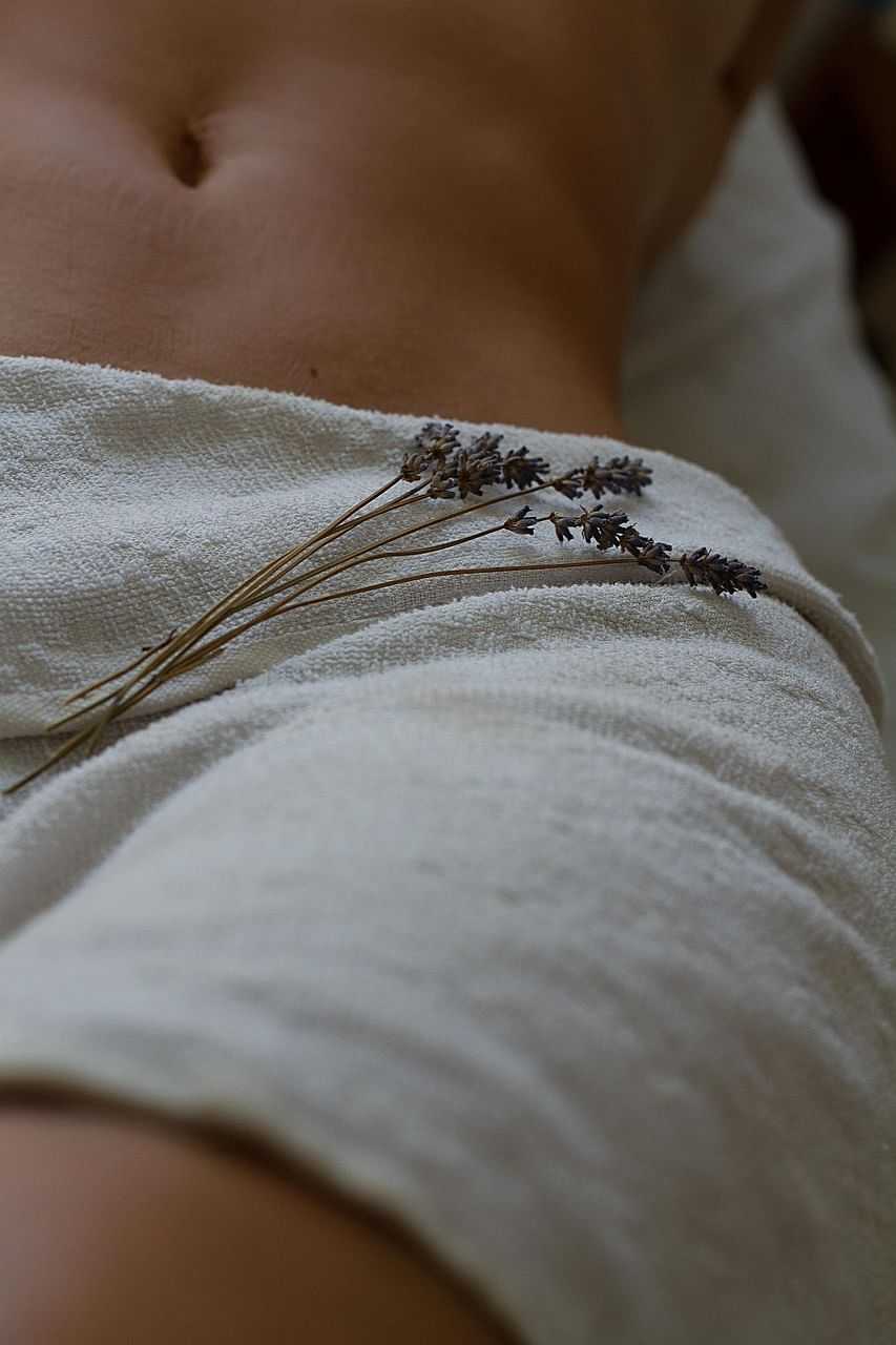 Towel covering body with lavender sprigs on it, creating a serene spa-like atmosphere.